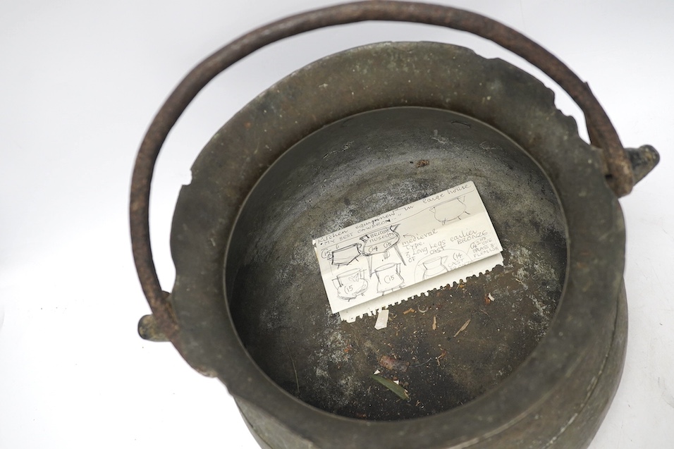 A 16th / 17th century bronze cauldron, 21.5cm tall with handle down. Condition - poor, losses and repairs to rim and body